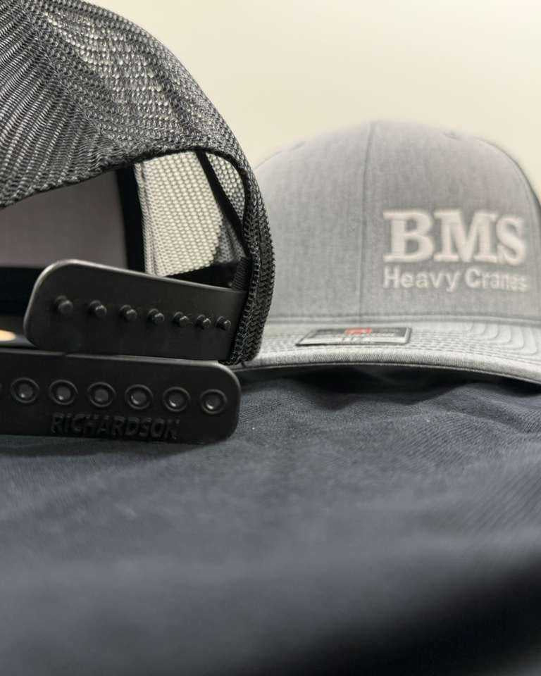 Close-up of BMS Trucker Hat's snapback closure and mesh back, highlighting adjustable fit and durable construction.