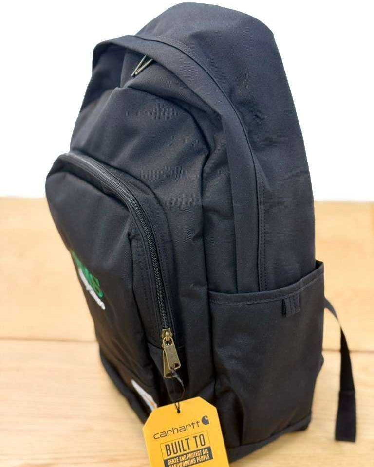 Side angle of BMS Black Carhartt 25L Backpack highlighting water-repellent fabric, side pocket, and Carhartt tag for industrial use.