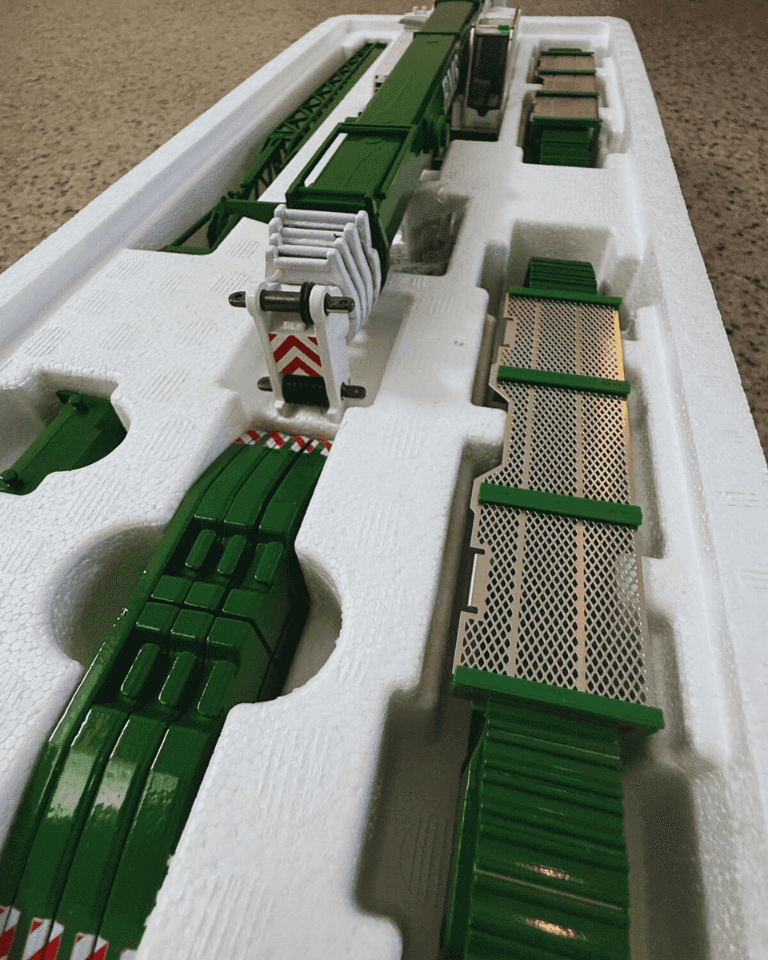 Packaged BMS Liebherr LTR 1220 1:50 scale model crane with green and white parts neatly arranged in foam tray for collectors.