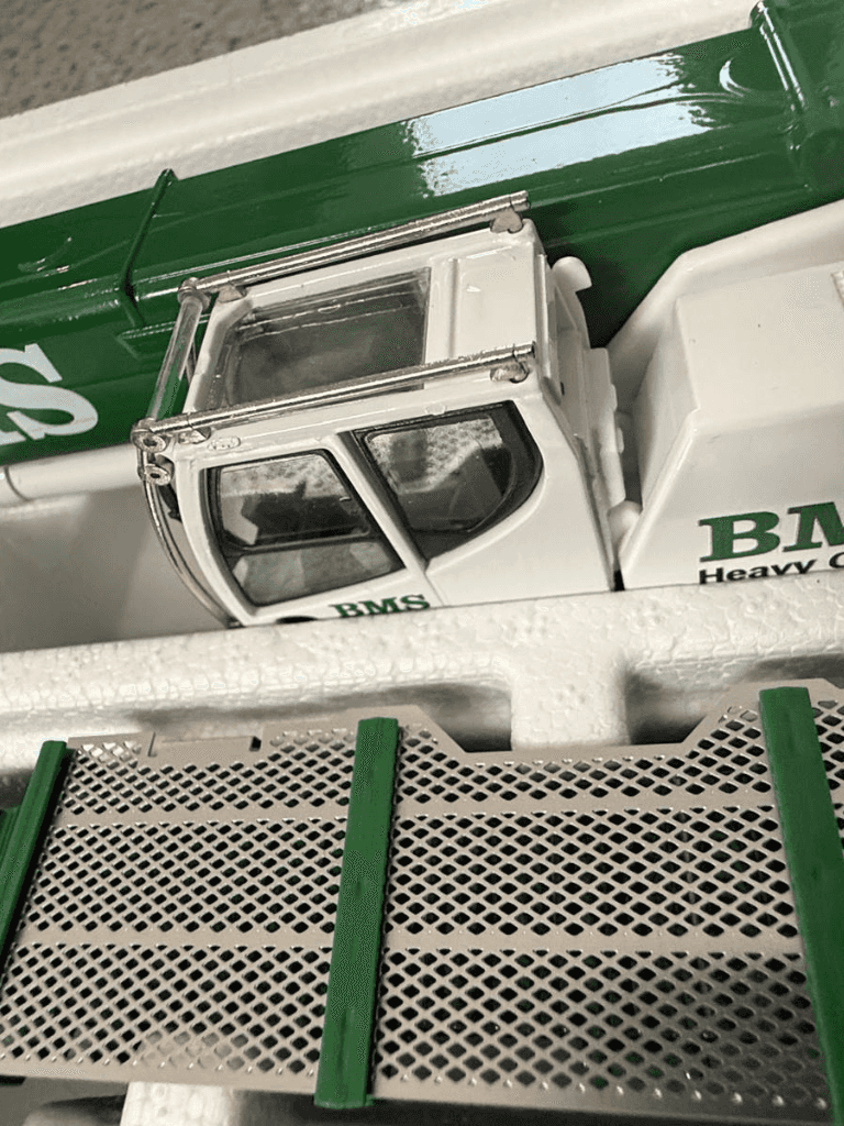 Close-up of BMS Liebherr LTR 1220 model crane cab in 1:50 scale, showcasing detailed interior and branding in protective packaging.