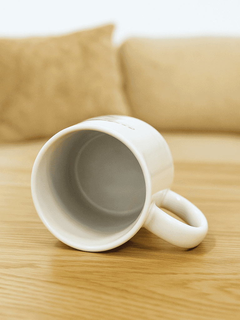 Angled view of BMS white ceramic mug showing spacious interior and sturdy handle, perfect for daily use in kitchen or workplace settings.