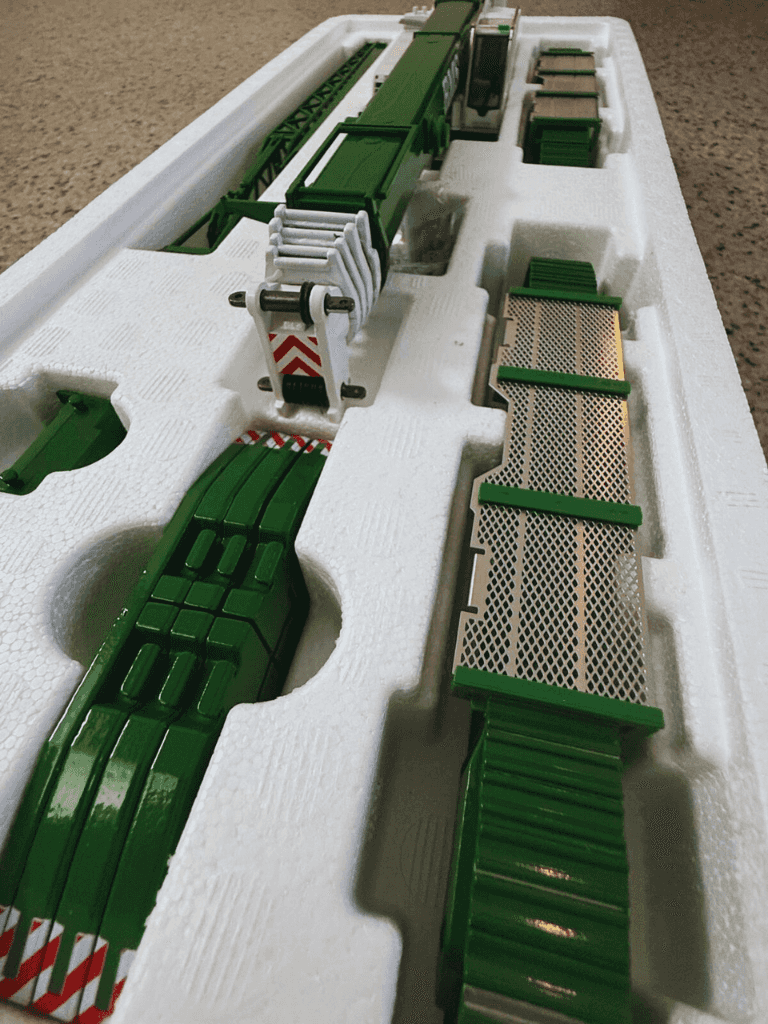 Packaged BMS Liebherr LTR 1220 1:50 scale model crane with green and white parts neatly arranged in foam tray for collectors.