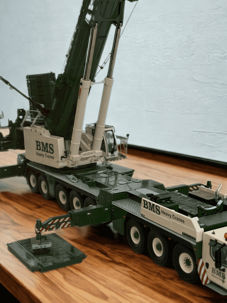 Fully extended BMS Liebherr LTM 1650 model crane on display with riggers, showcasing premium craftsmanship in 1:50 scale collector series.